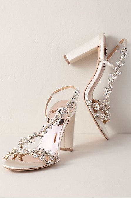 a pair of white high heeled shoes with crystal embellishments