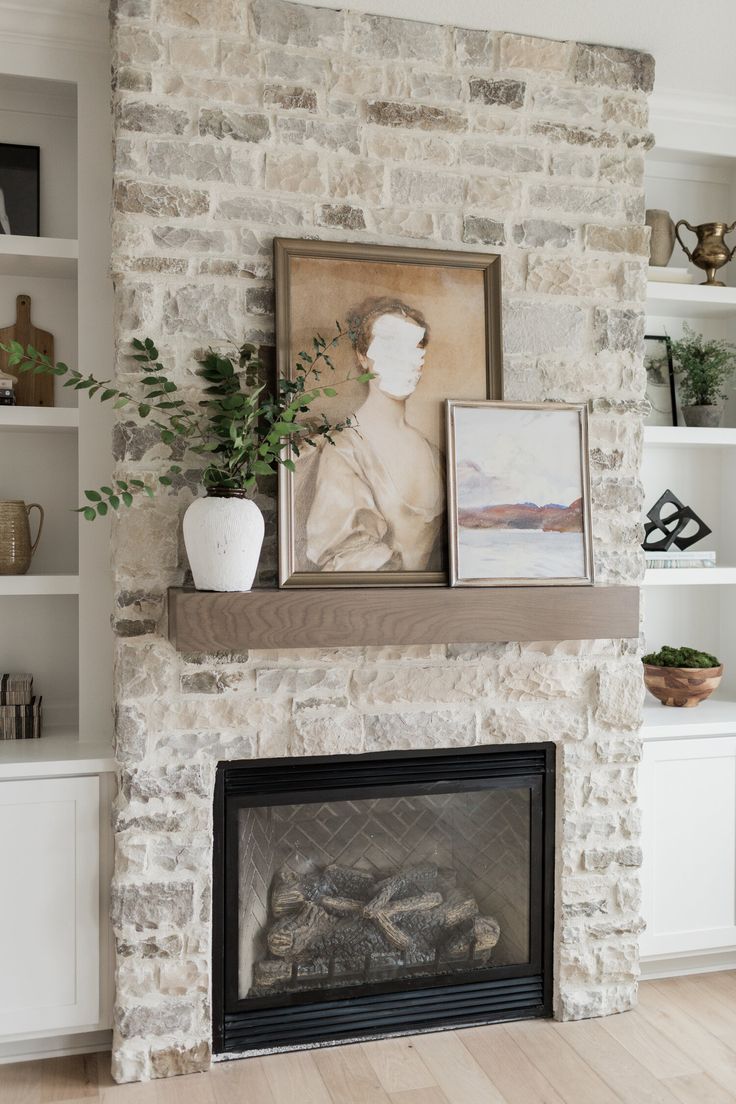 a living room with a fire place and pictures on the fireplace mantel above it