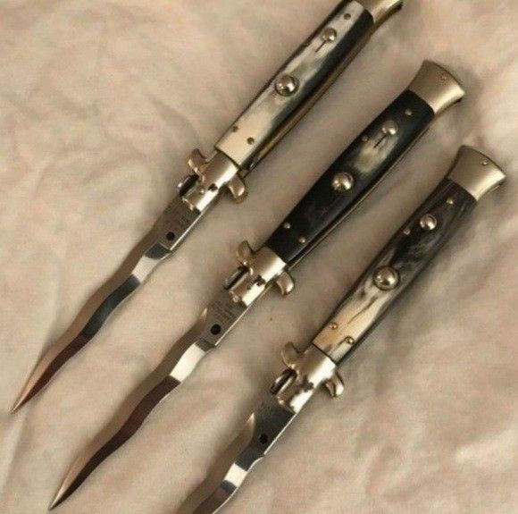 three knives are laying on the bed together