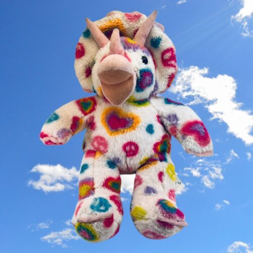 a multicolored stuffed animal hanging in the air on a clear day with blue sky and clouds