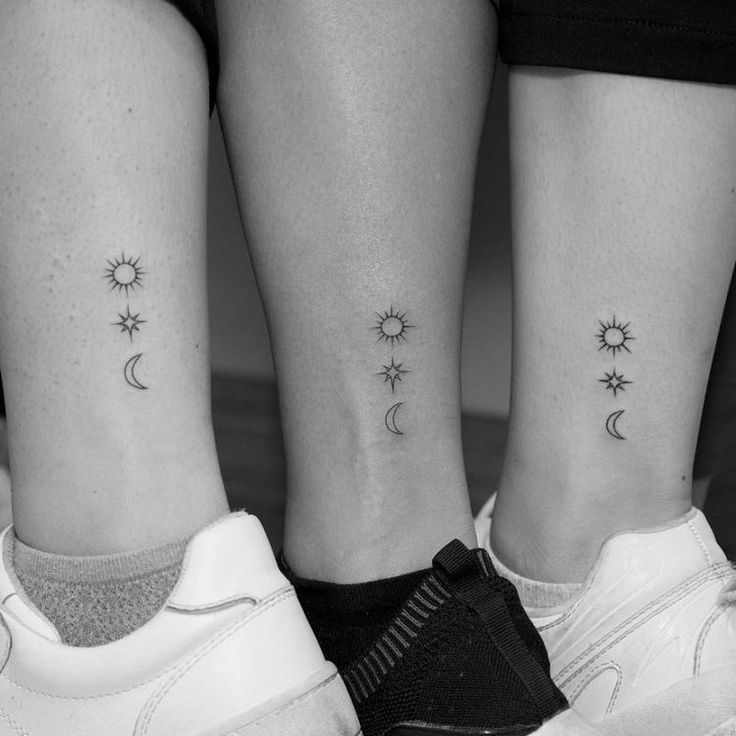 two people with matching tattoos on their legs, both showing the same sun and moon