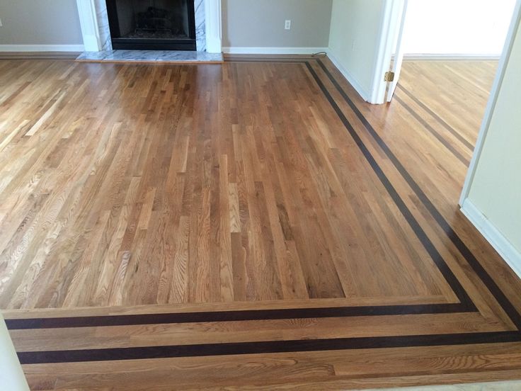 an empty living room with hard wood flooring