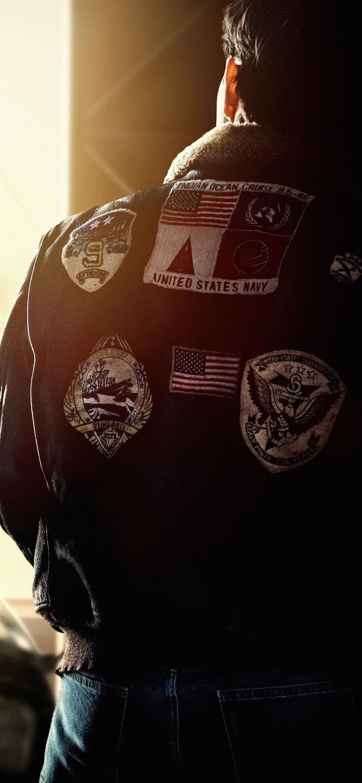 the back of a man's jacket with patches on it and an american flag