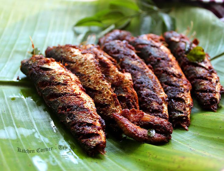 grilled fish sitting on top of a green leaf