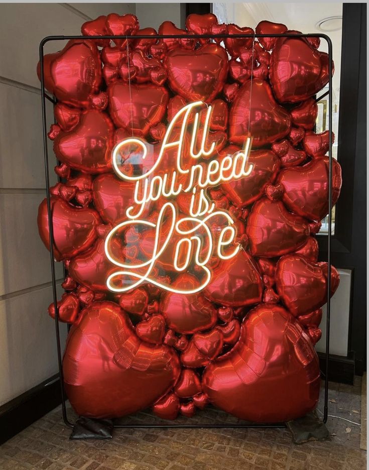 red heart shaped balloons with the words all you need is love written on one side