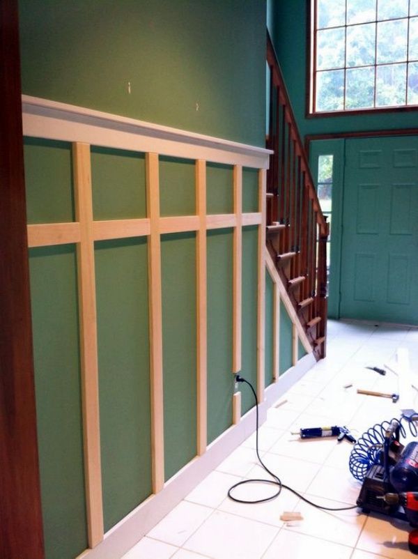 a room that has been painted green with white trim on the walls, and tools in front of it