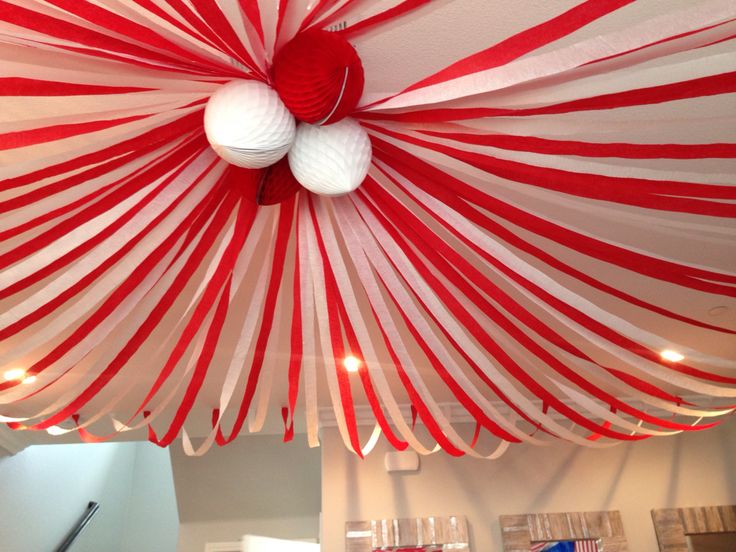 a red and white striped ceiling with two balls hanging from it's center piece