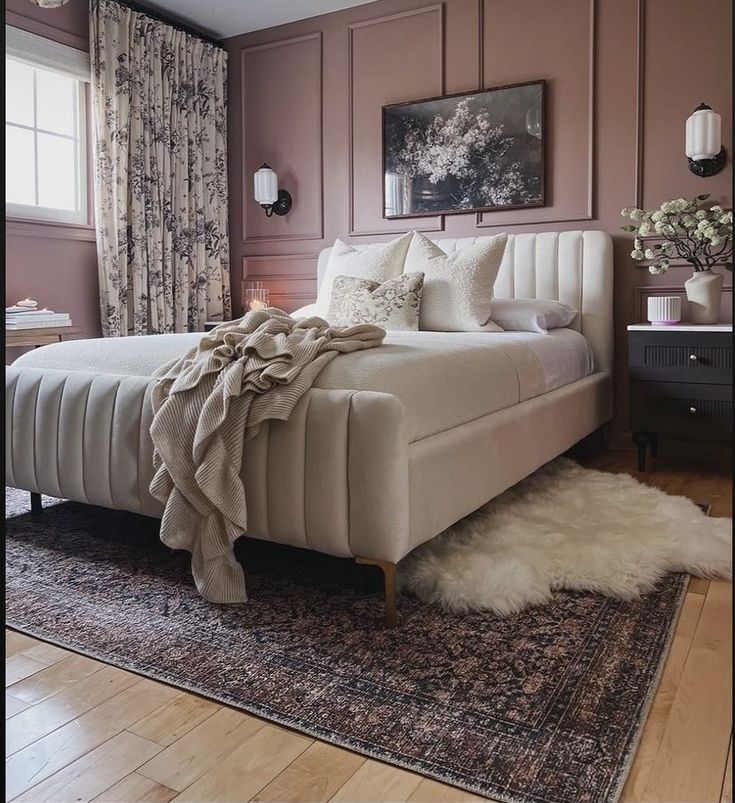 a large bed sitting on top of a wooden floor next to a window covered in curtains