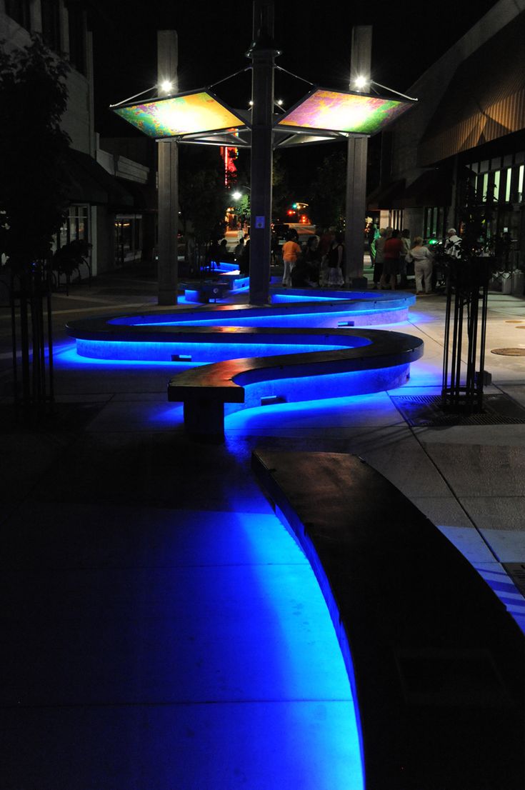 illuminated benches on the sidewalk at night