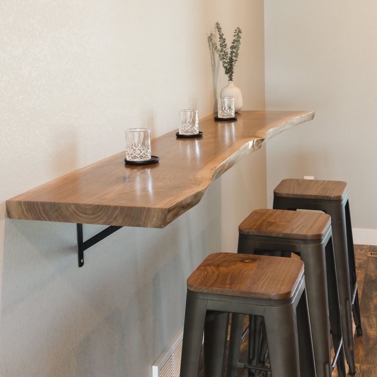 three bar stools sit at the edge of a counter