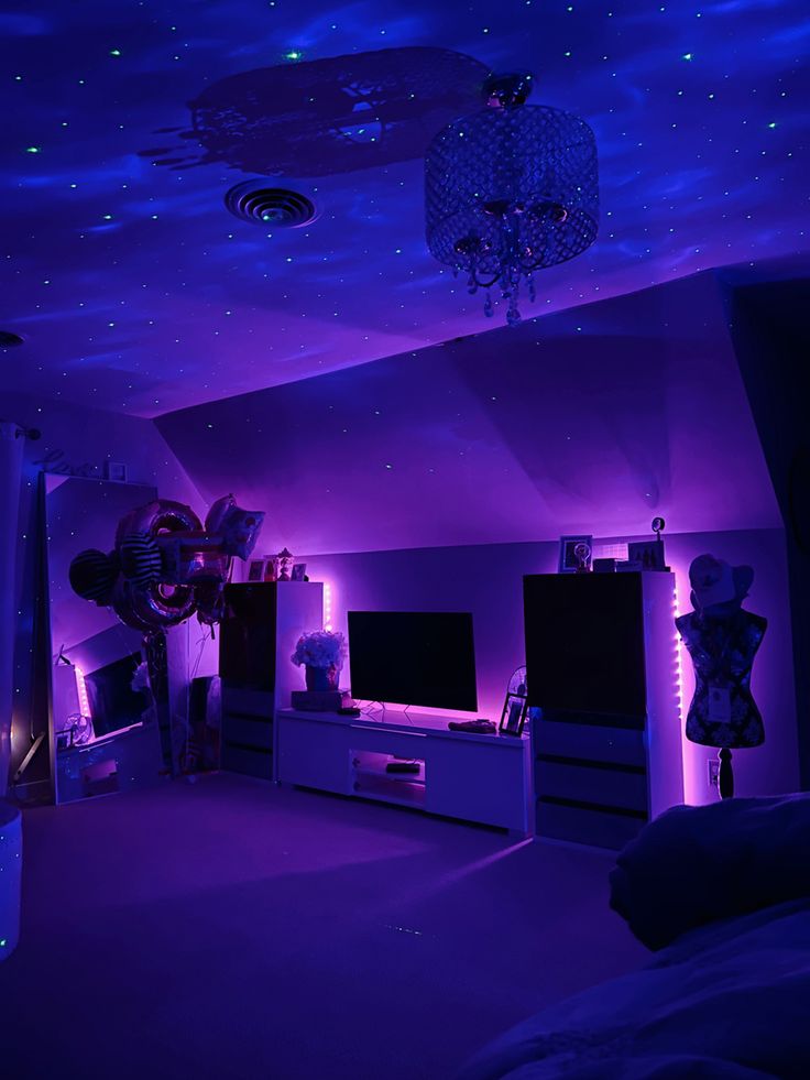 a room with purple lighting and decorations on the ceiling, in front of a flat screen tv