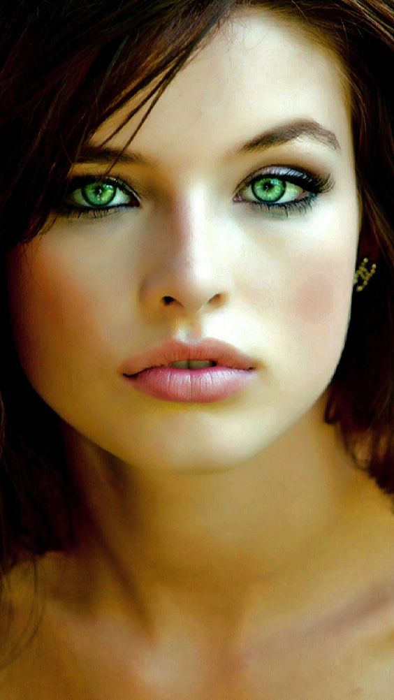 a woman with green eyes is posing for the camera