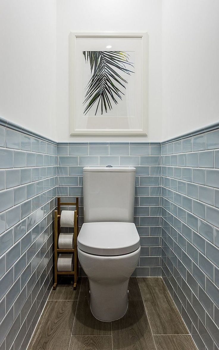 a white toilet sitting in a bathroom next to tiled walls