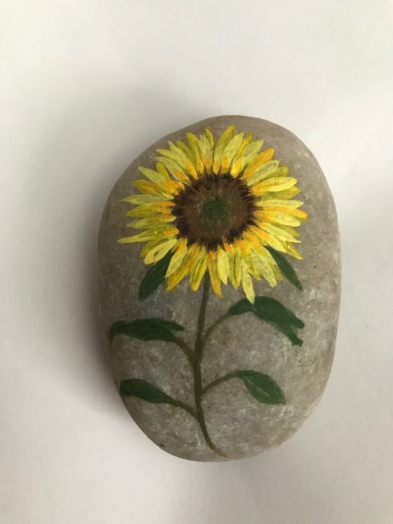 a painted rock with a sunflower on it