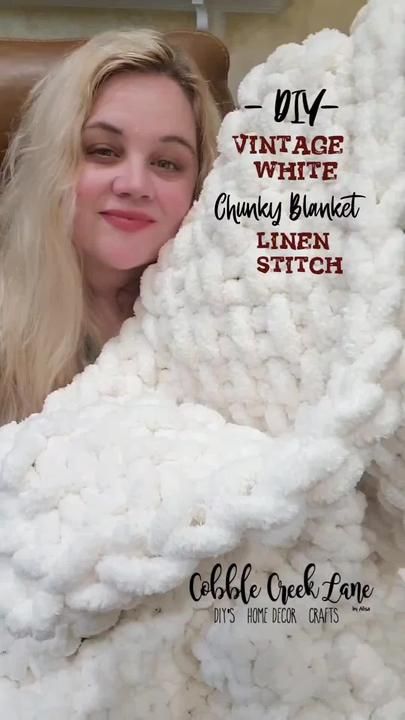 a woman sitting in a chair under a white blanket with the words vintage white chunky blanket written on it