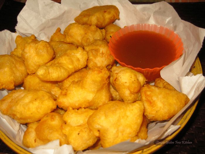 some fried food is in a bowl with sauce on the side and paper napkins