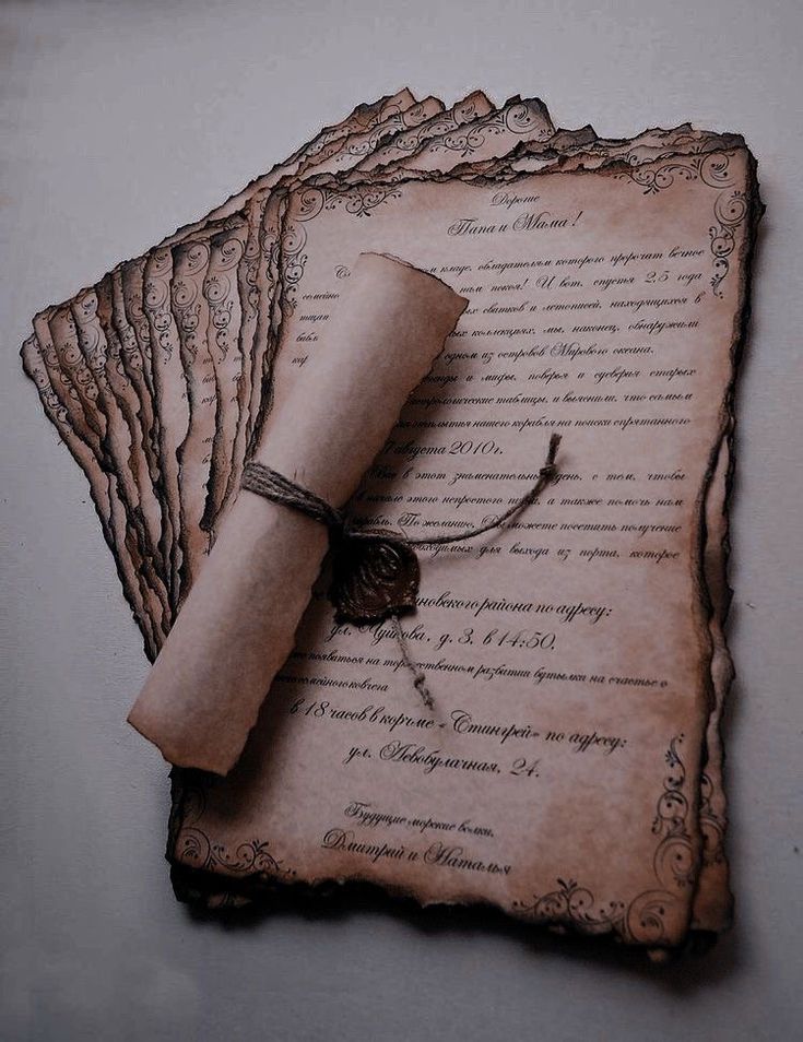 an old scroll with a ring on top of it and some paper attached to it