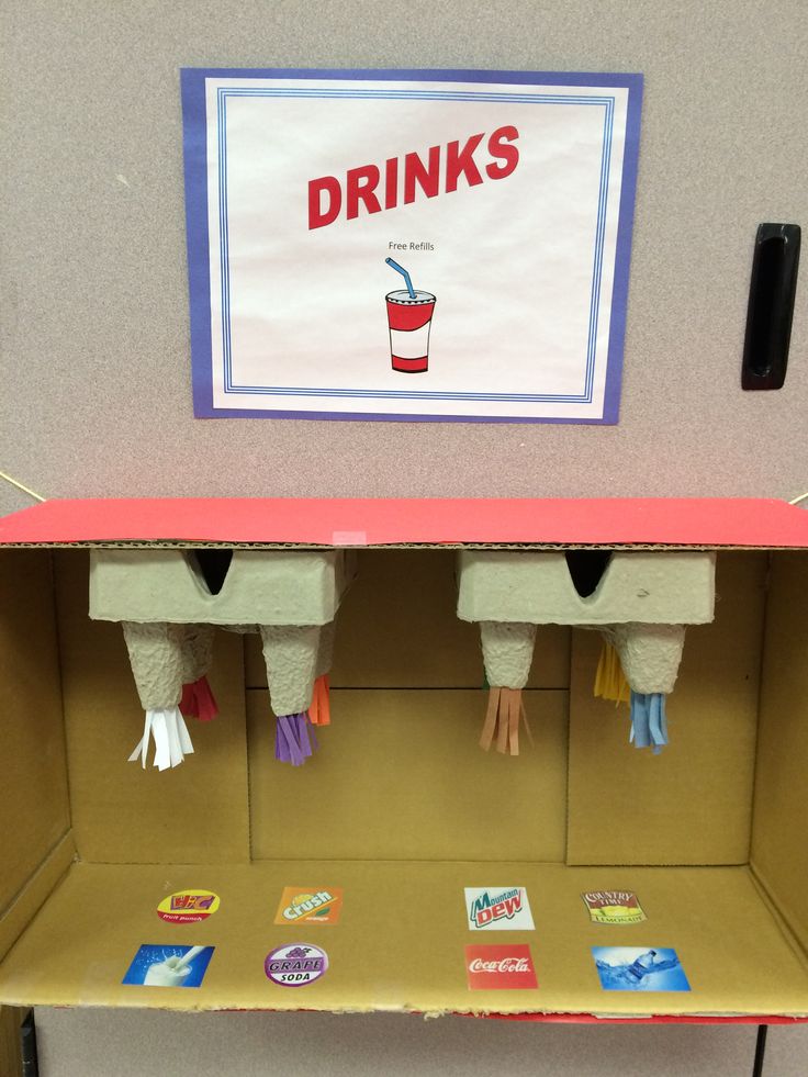 an office cubicle with drinks on the shelf and other items in front of it