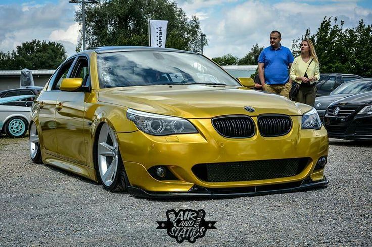 two people standing next to a yellow car