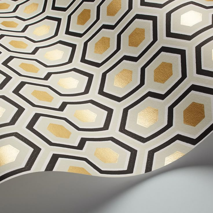 a white and gold wallpaper with hexagonal shapes on it's surface