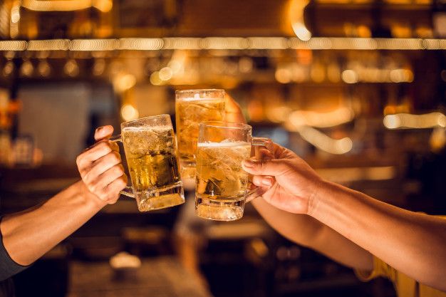 two people are toasting with beer glasses