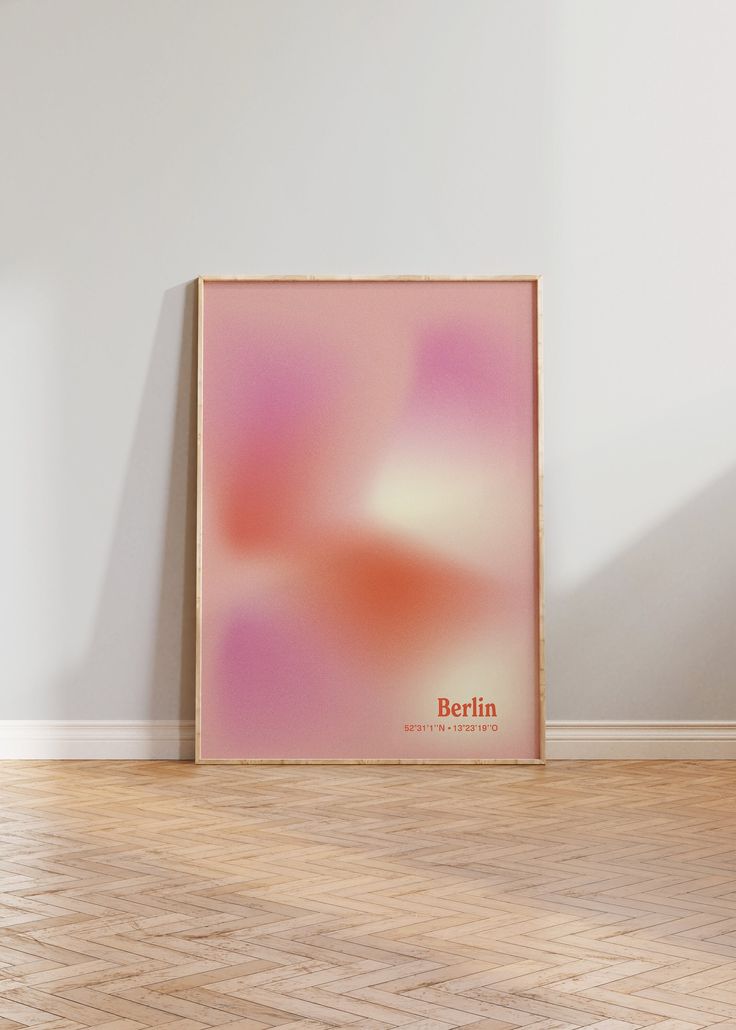 a pink poster sitting on top of a hard wood floor next to a white wall