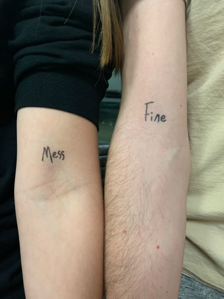 two people with matching tattoos on their arms that say, fine and mes written in cursive font