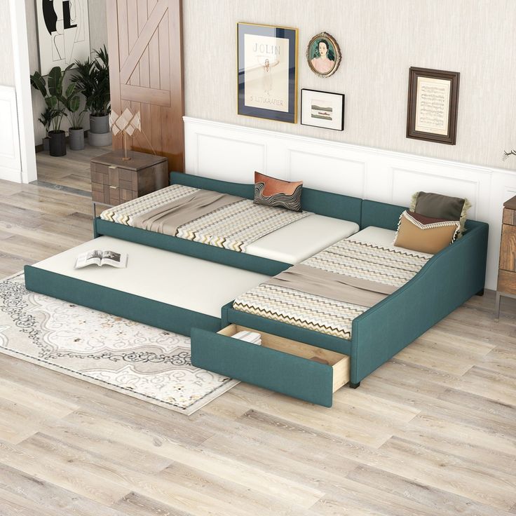 a bed that is sitting in the middle of a room with drawers on each side