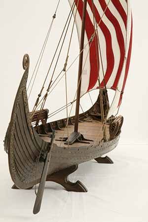 an old model boat with a red and white flag on it