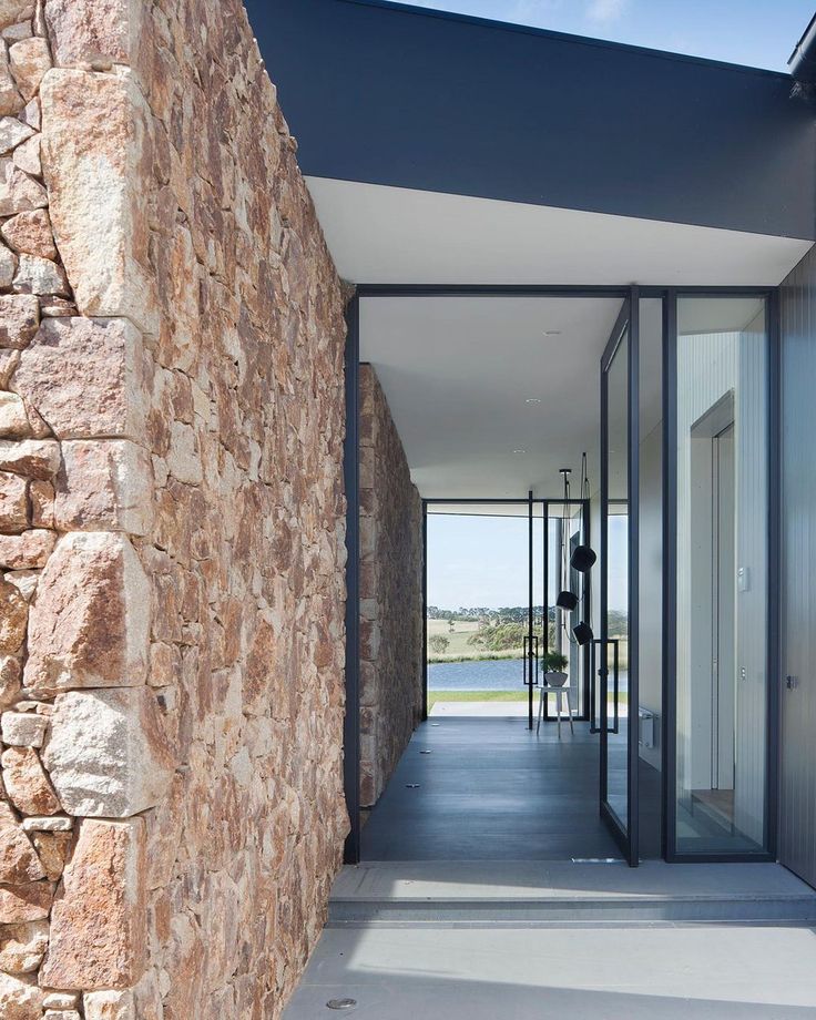 an entrance to a house with stone walls and doors leading into the outside area,