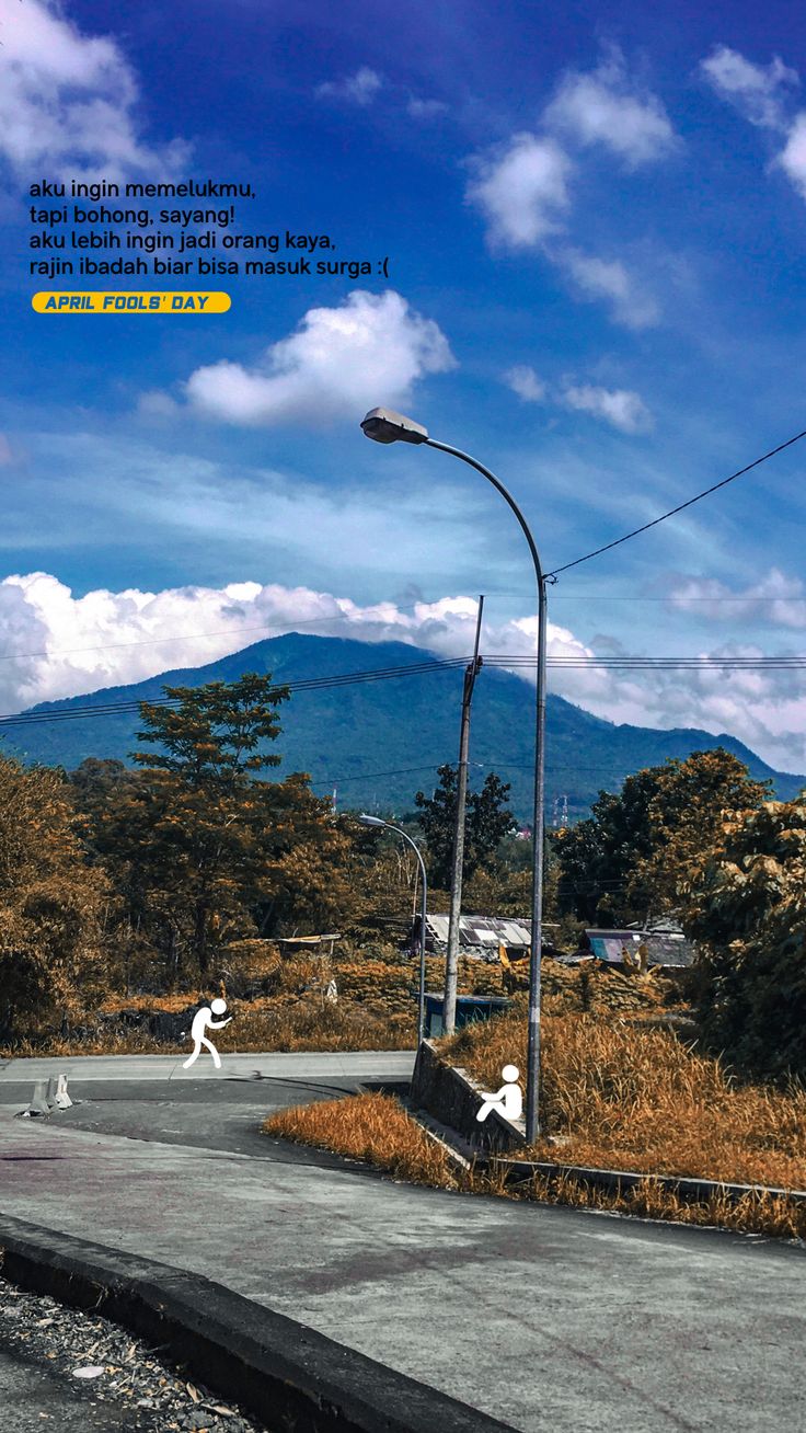 an empty street with mountains in the background and blue skies above it, as well as clouds