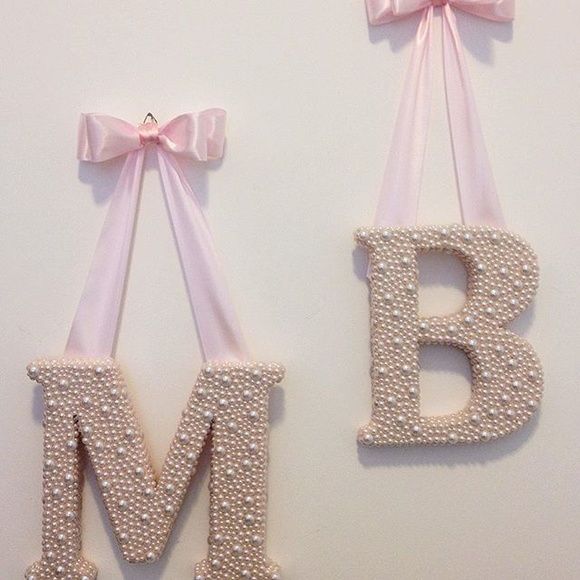 two letters are decorated with pink bows and ribbons for the baby's first birthday