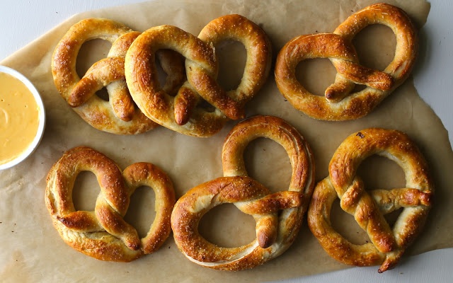 several pretzels on parchment paper with dipping sauce