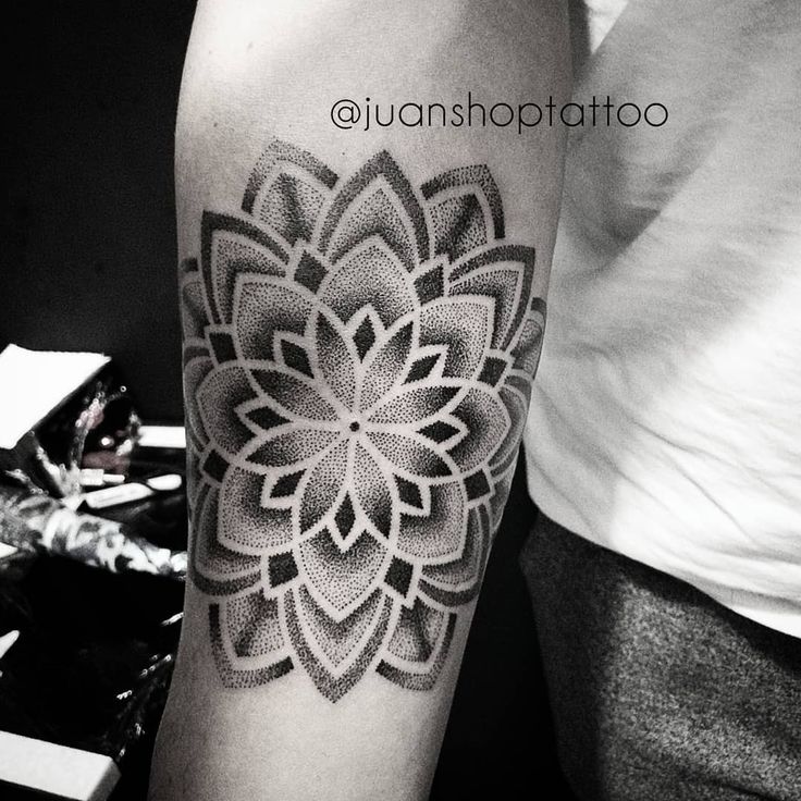 a black and white photo of a woman's arm with a flower tattoo on it