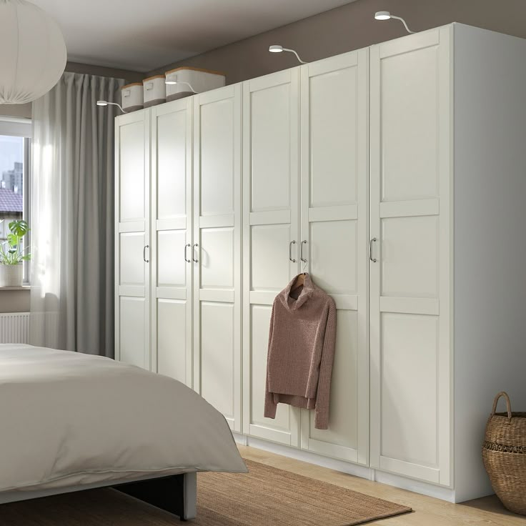 a bedroom with a bed, closets and a large window in it's corner