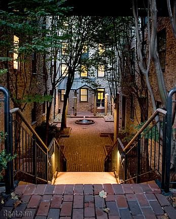 an entrance to a building with steps leading up to it and trees in the background