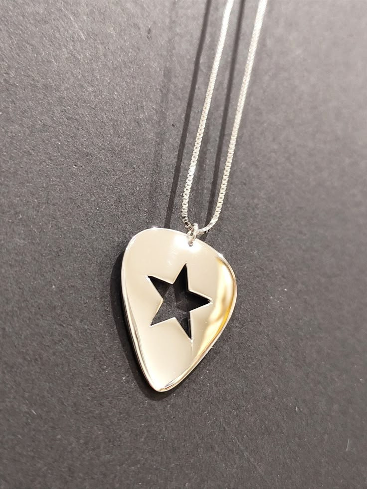 Brand New unique pendant design! Incorporating a Star within the Guitar Pick. - 925 Sterling Silver (Gold Plated) - Box Chain - 45.7 cm (18 inch) Chain - Pendant Measures 25mm x 21mm (1.2mm depth) - Weight 5.7 grams inc chain - Premium Leatherette Display Box - Available in Gold or Silver Nickel-free Silver Jewelry For Concerts, Sterling Silver Jewelry For Concerts, Star Jewelry Aesthetic, Cool Guitar Picks, Guitar Pendant, Guitar Pick Necklace, Pendant Designs, Guitar Accessories, Funky Jewelry