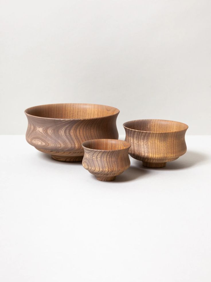 three wooden bowls sitting next to each other