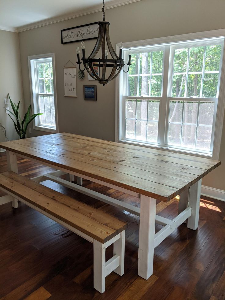 a large wooden table with two benches in front of it on a hard wood floor