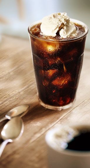 an iced drink with ice sits on a wooden table