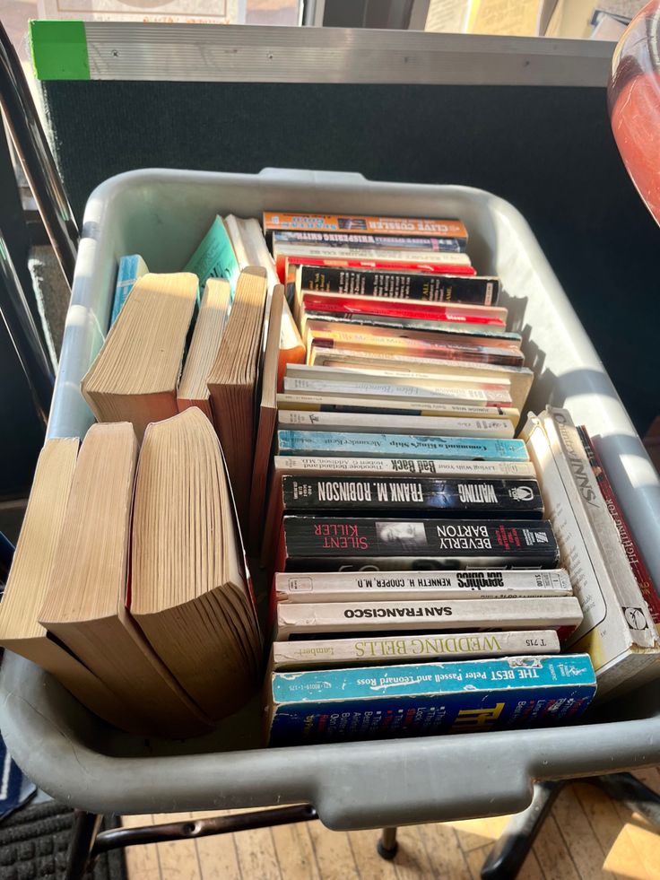 a cart filled with lots of books on top of a wooden floor