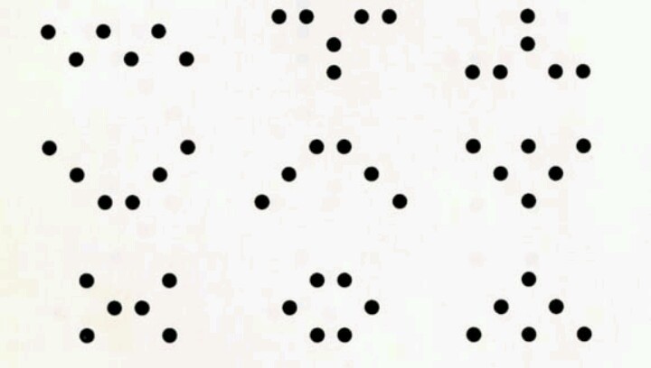 a white wall with black dots on it