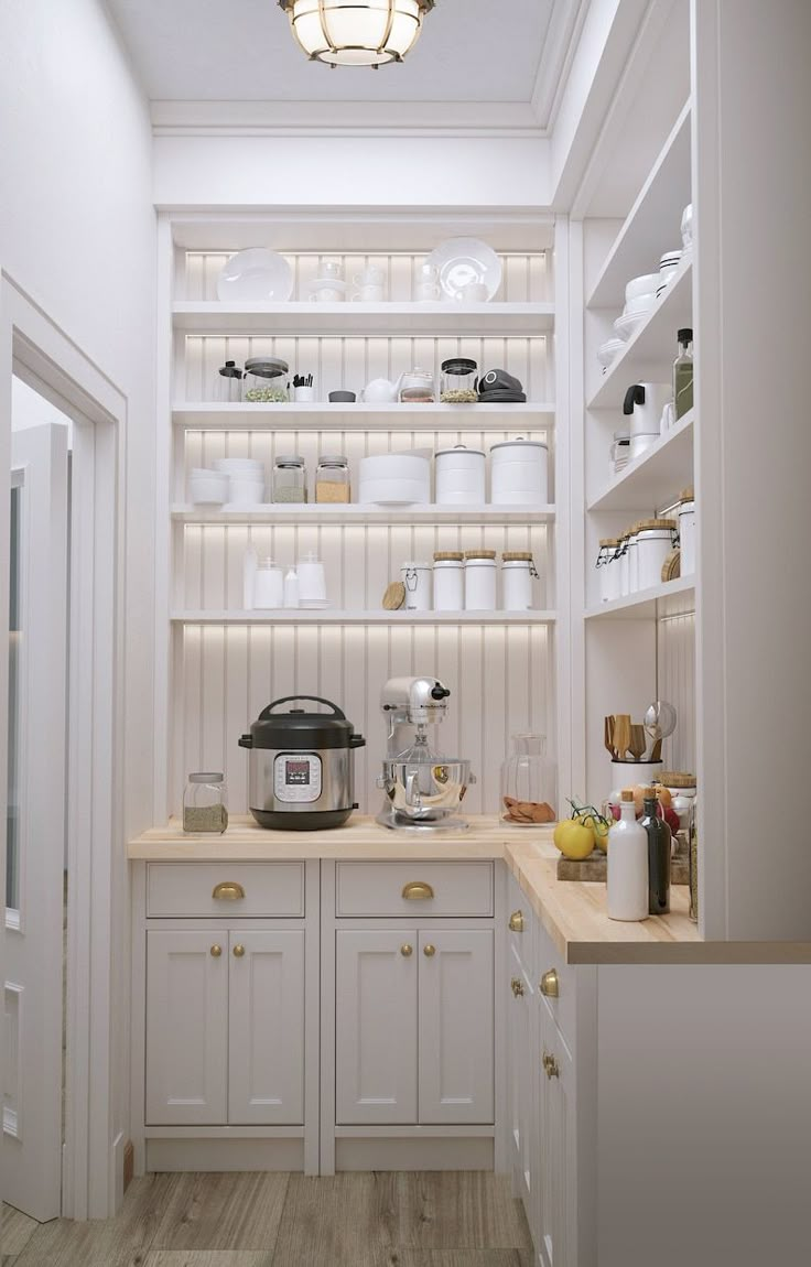 a kitchen with white cupboards and shelves filled with dishes, pots and pans