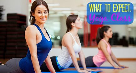 three women are doing yoga on mats in a gym room while one woman is smiling at the camera