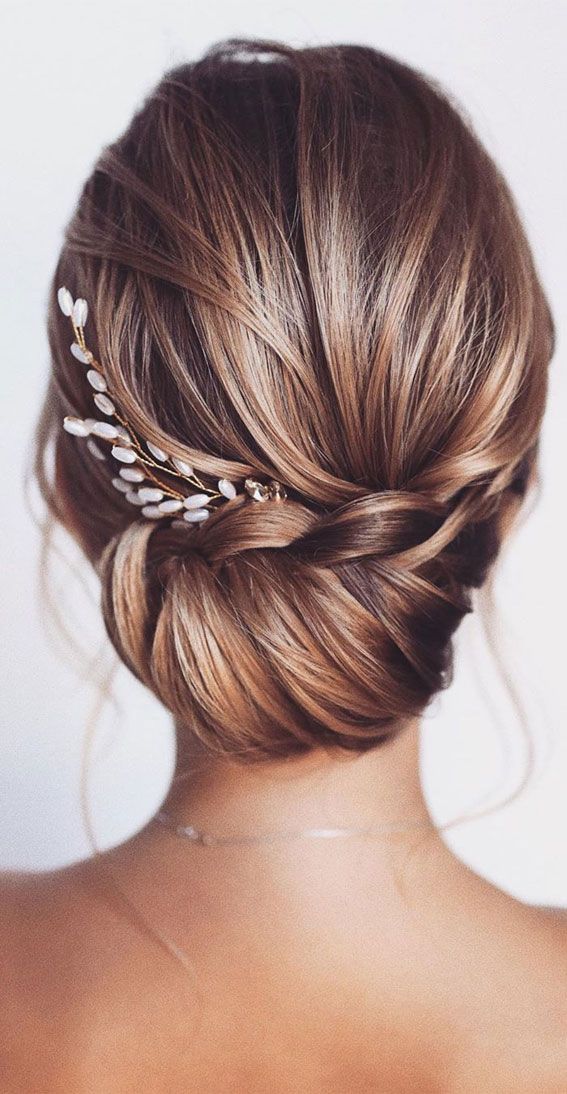 the back of a woman's head wearing a hair comb with pearls in it