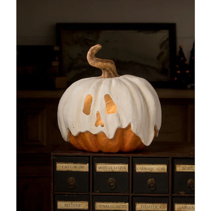 a carved pumpkin sitting on top of a stack of books