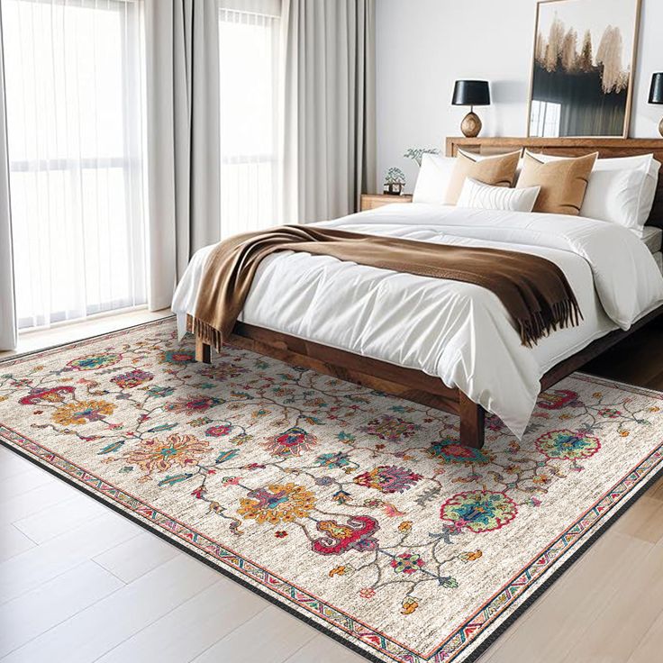 a large bed sitting in a bedroom on top of a wooden floor next to a window