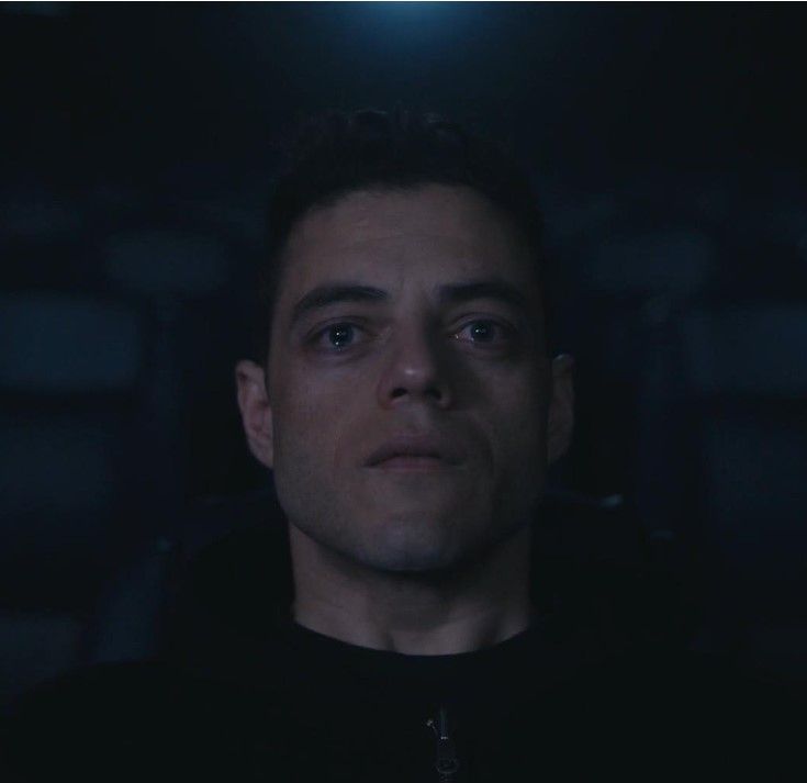 a man in a dark room staring at the camera