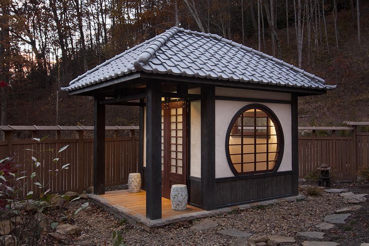 a small white and black building in the woods