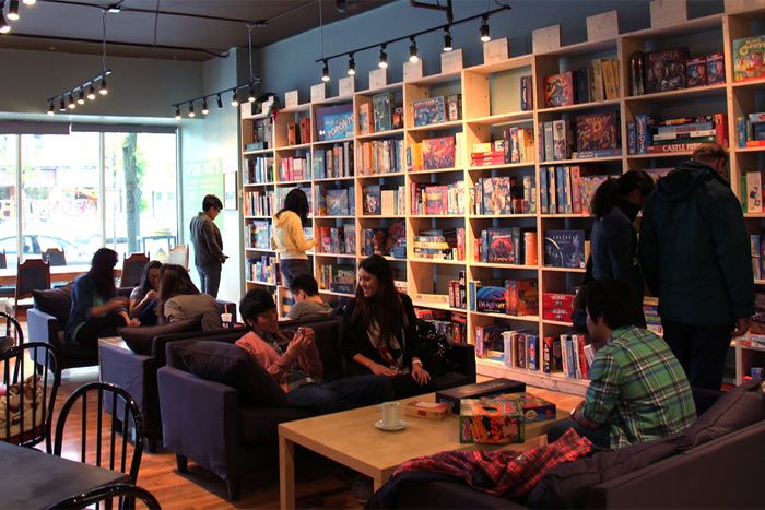 a group of people sitting around in a room with bookshelves on the wall